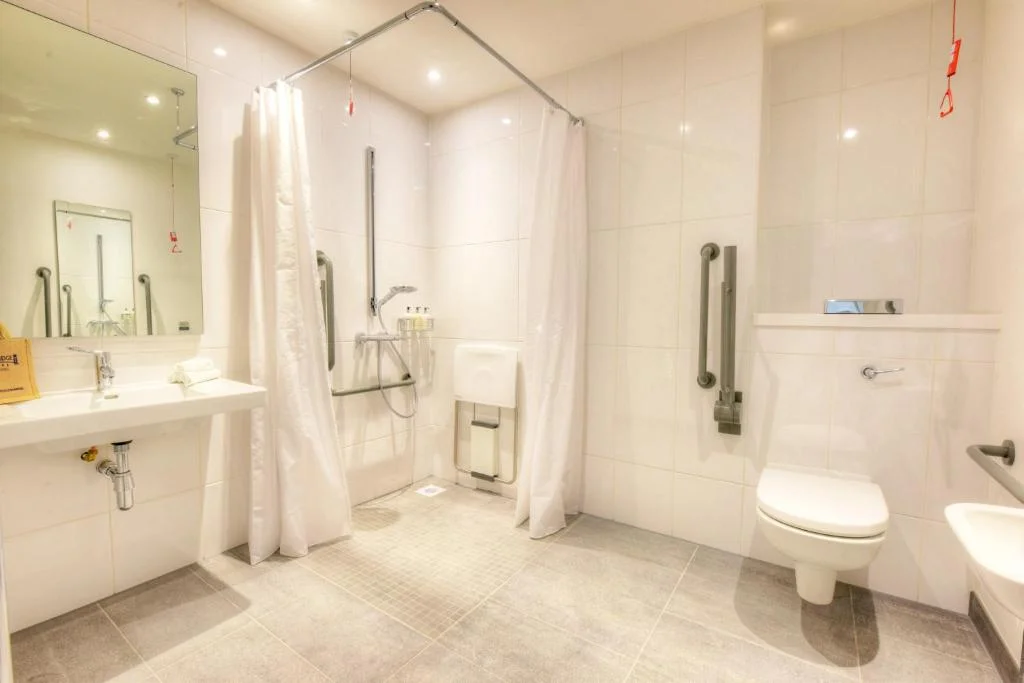 Stylish wet room with level access shower, seat and grab rails